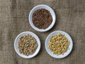 Flax seeds, raw wheat germ and buckwheat seeds on three plates Royalty Free Stock Photo